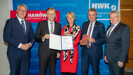 NRW-Bildungsministerin Dorothee Feller (M.) erhält die Ehrenplakette der HWK Münster von HWK-Präsident Hans Hund (2.v.l.), Vizepräsident Bernhard Blanke (2.v.r.) und Jürgen Kroos (r.) und Hauptgeschäftsführer Thomas Banasiewicz (l.).