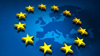 Das Bild zeigt die Flagge der Europäischen Union mit zwölf gelben Sternen auf blauem Hintergrund und einer angedeuteten Europakarte.